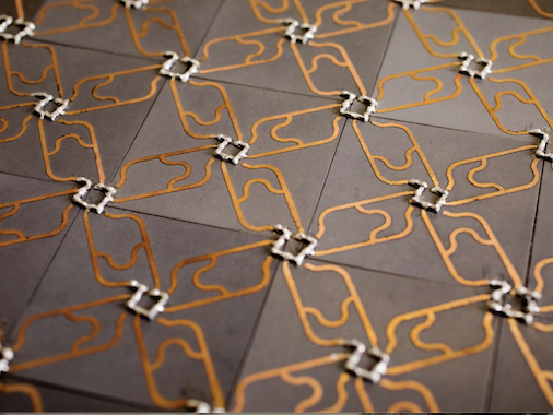 Photo of a metamaterial composed of a pattern of resonators. The defect appears as a pentagon in an otherwise regular array of circuit elements. (Credit: K. Peterson)