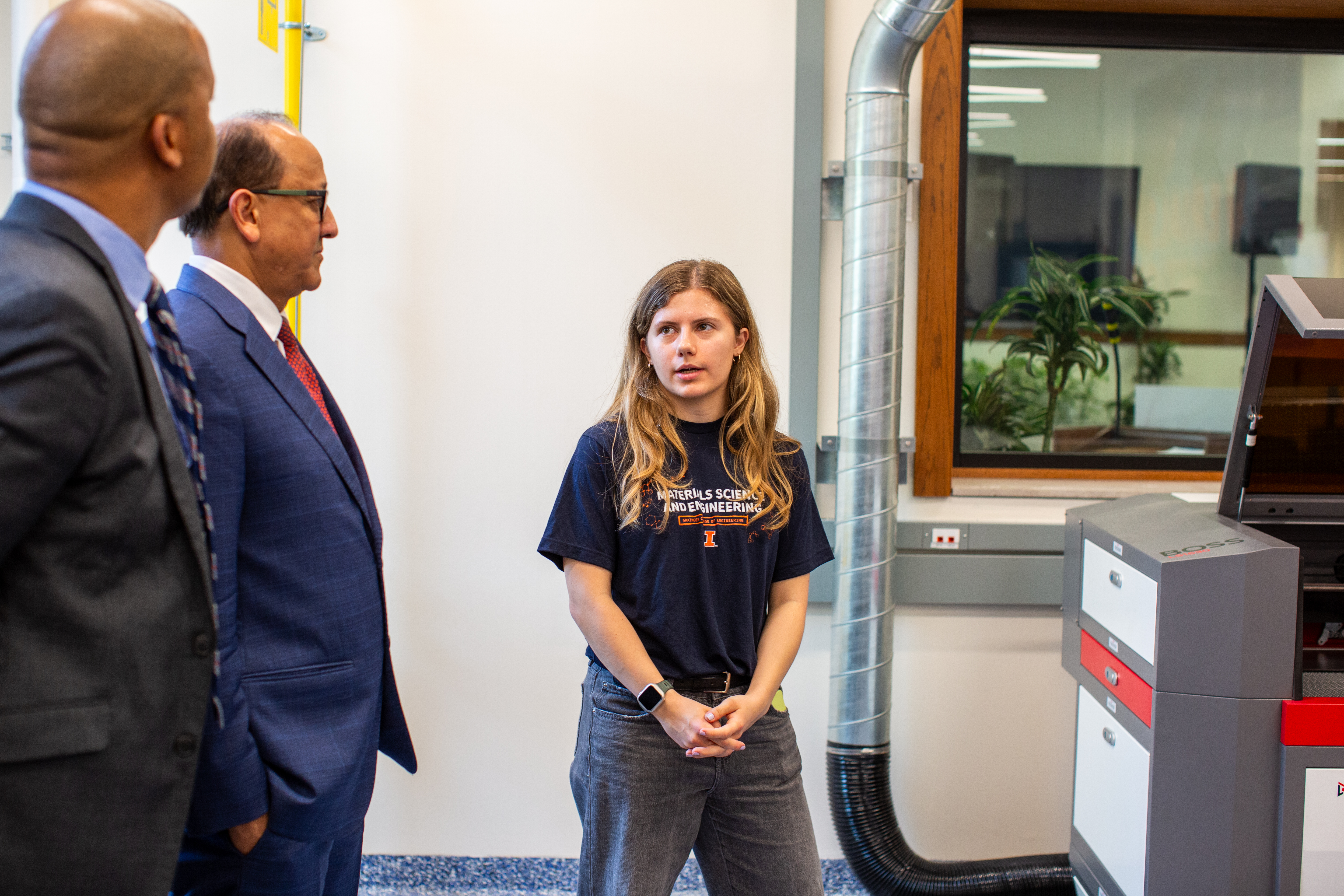 Mia Mikolajczak, leader of the inaugural Eltoukhy Family Innovation Lab student leadership team, shows Dale Wright and Rashid Bashir equipment.