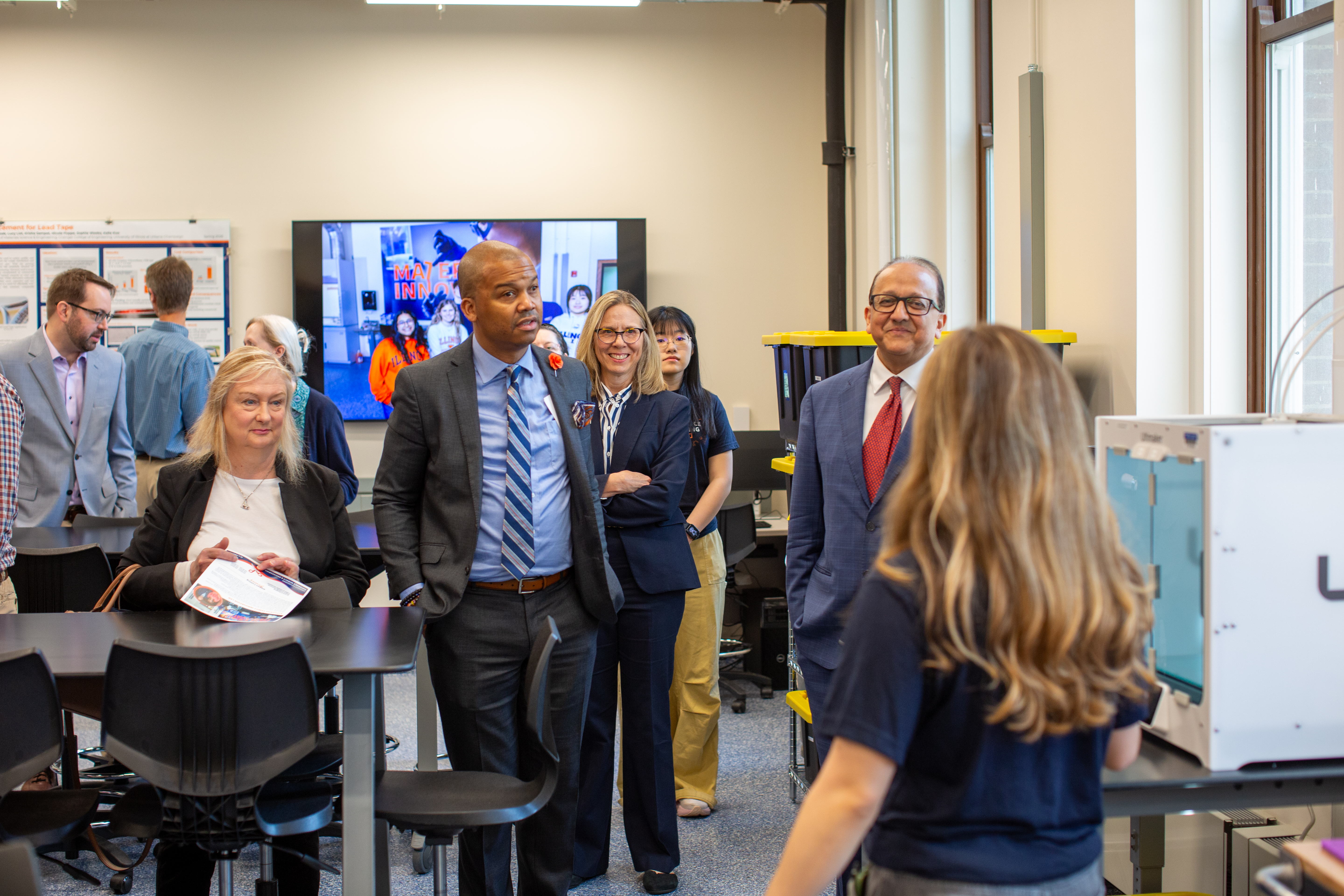 A group of people listens attentively as Mia Mikolajczak, leader of the inaugural Eltoukhy Family Innovation Lab student leadership team, explains equipment.