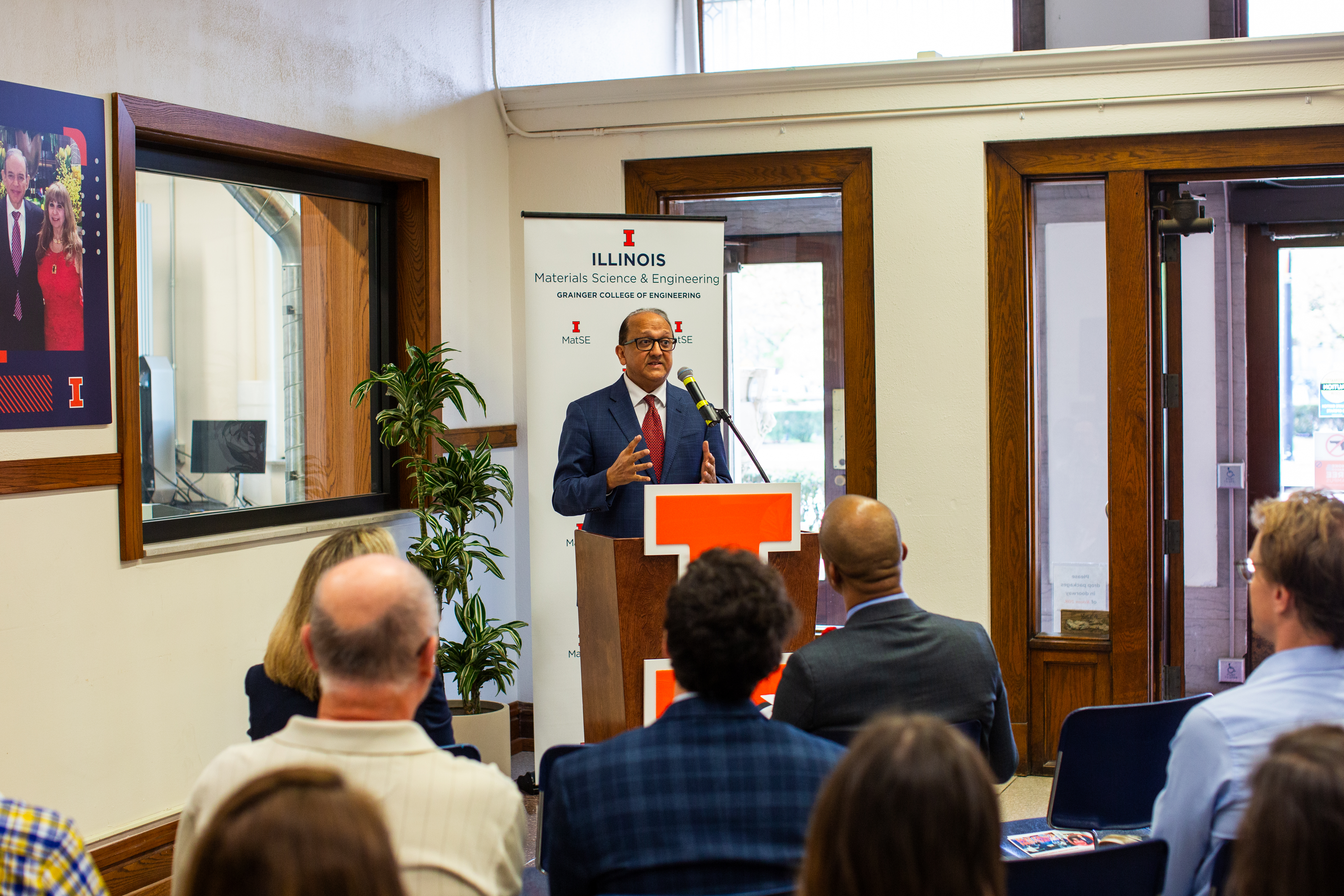 Illinois Grainger Engineering Dean Rashid Bashir shares remarks at the Eltoukhy Family Innovation Lab ribbon cutting event. He is standing in front of the lab's viewing window and at a podium.