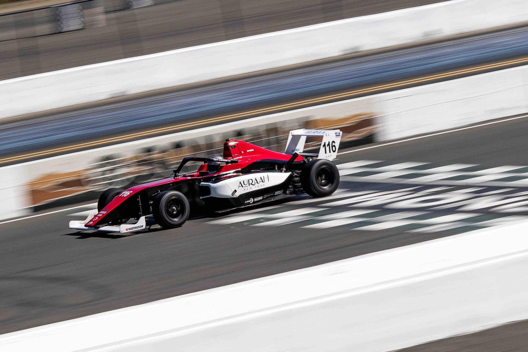 Yana Kapoor's F4 vehicle speeds by in a blur at the track.