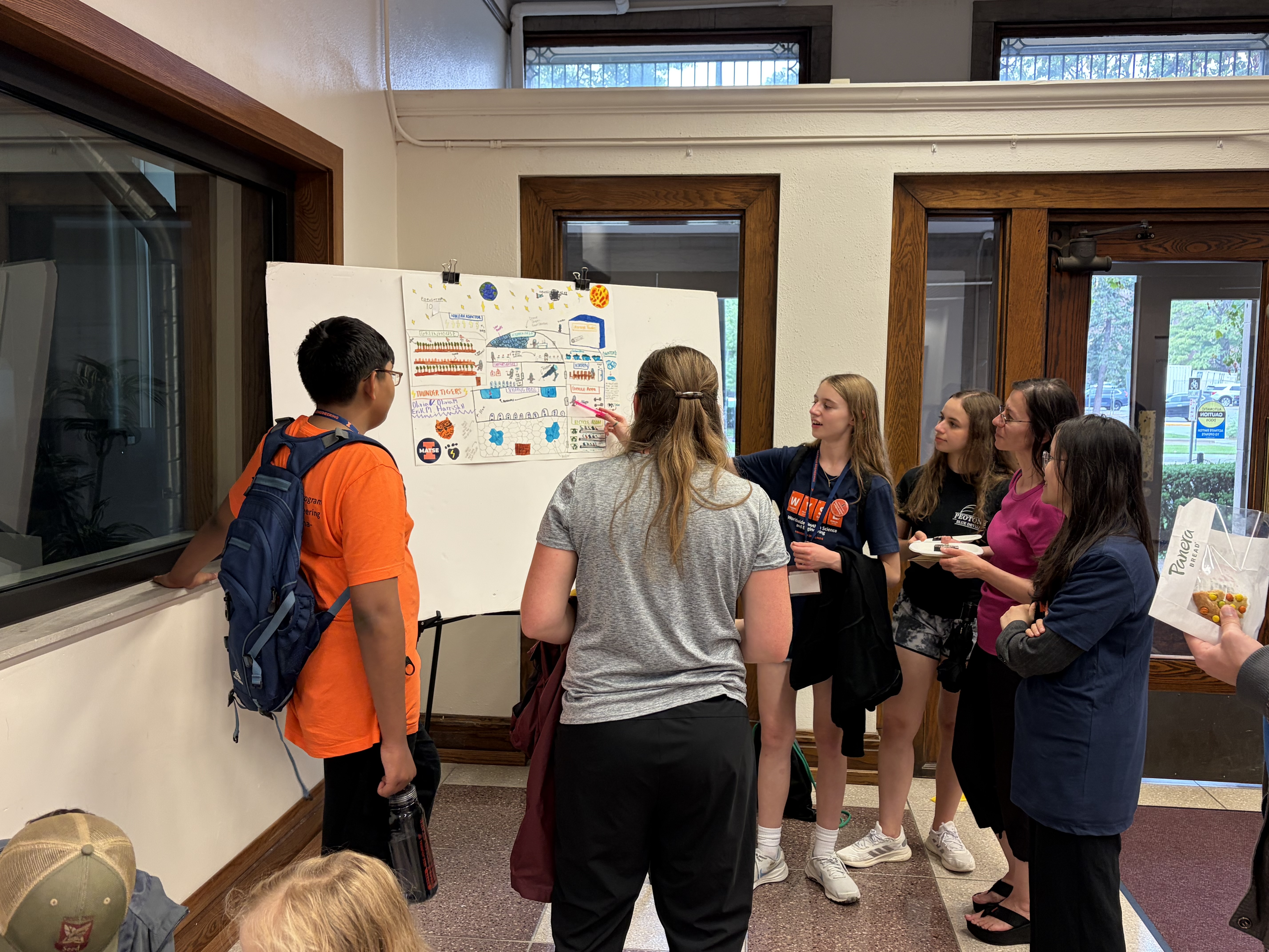 Students show off their poster on the final day of 2026 Mid-GLAM camp. Each group came up with a design for what a moon base could look like.