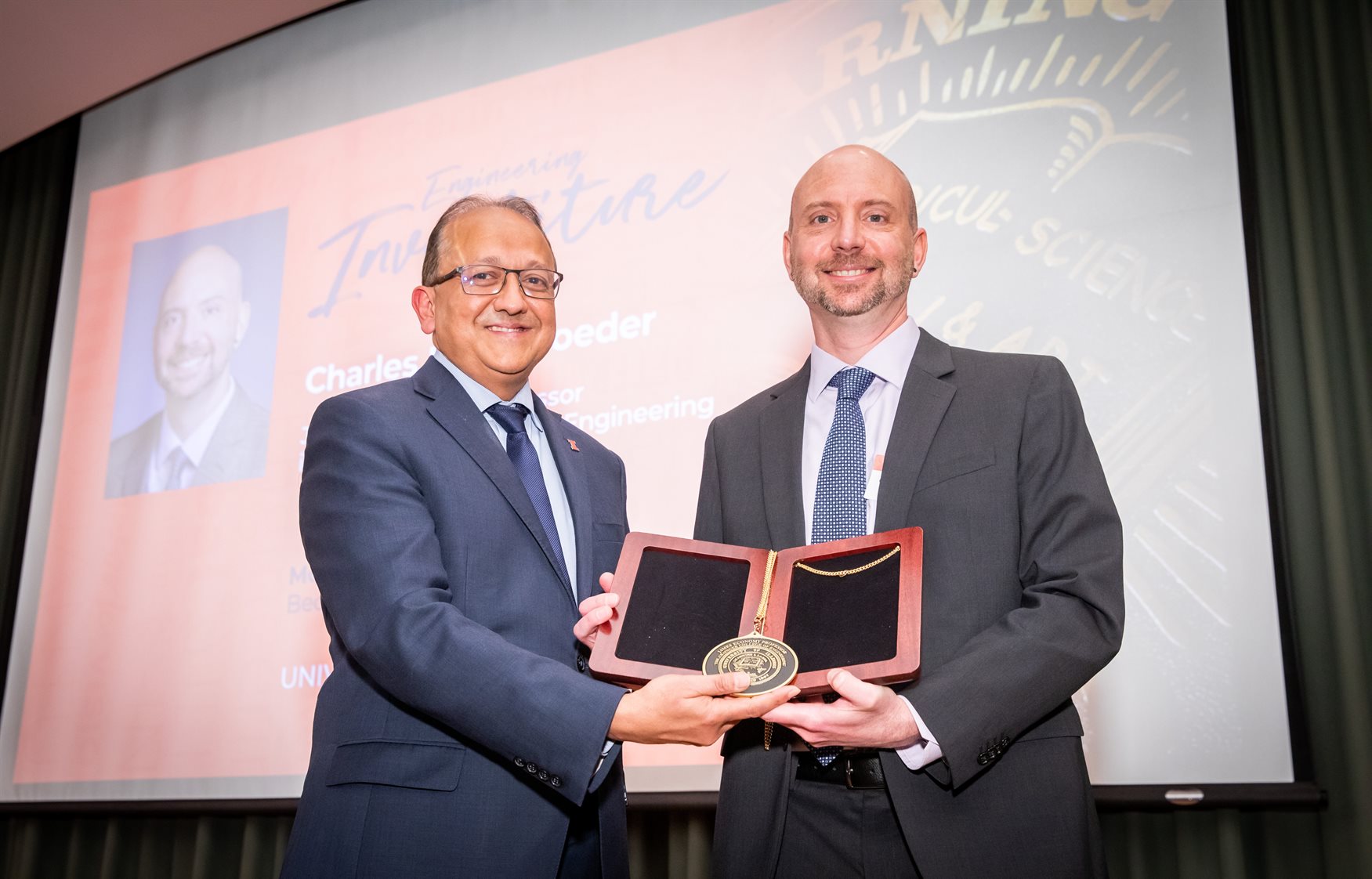 Fred Zwicky/Illinois News Bureau<br>Dean Rashid Bashir, left, awards Charles Schroeder his medallion for his investiture as the James Economy Professor in Materials Science and Engineering at the Beckman Institute in Urbana, Ill. on May 2.<br><br>"Charles is just a phenomenal colleague, a wonderful individual, a great researcher," Bashir said.