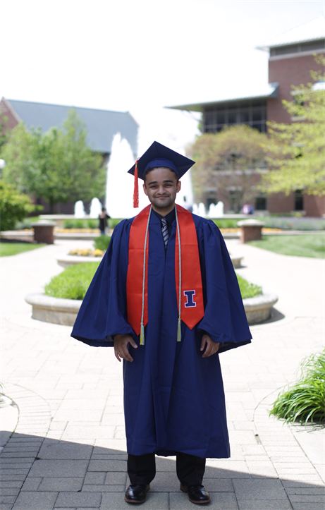 Vineet Tagare can't help but grin while taking a photo in his graduation regalia near the Alice Campbell Alumni Center in Urbana, Ill.