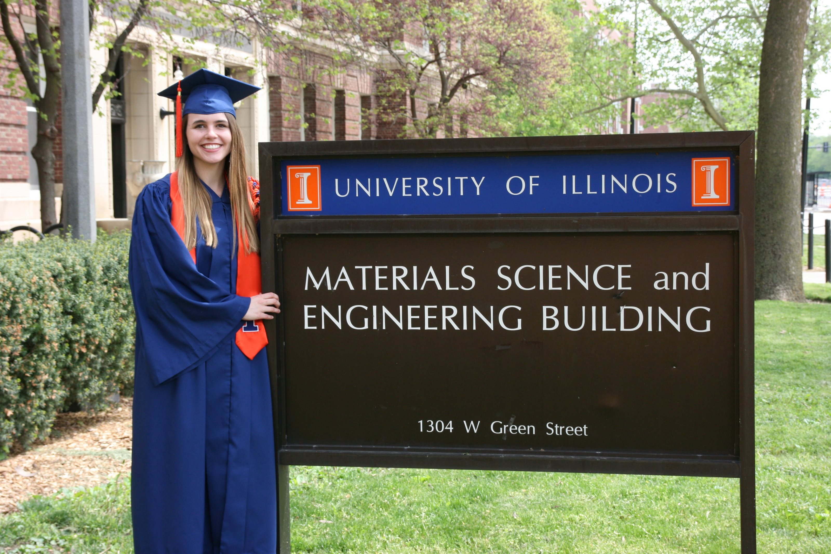 Lauren (Smith) Fey, an '18 MatSE alumnus and now computational researcher and doctoral student at the University of California, Santa Barbara, is all smiles in her graduation regalia outside the Materials Science and Engineering Building on Green Street in Urbana, Ill.