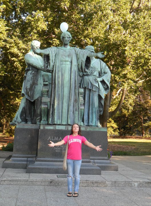 Janna (Eaves) Rathert stretches her arms out like the Alma Mater as a MatSE undergraduate student. The iconic statue can be seen along Green Street in Urbana, Ill.