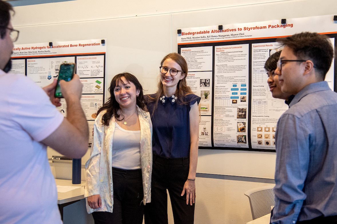 Montse Solis, left, and Sara Pfeil, second from left, pose for a photo during the annual presentation day at the Campus Instructional Facility in Urbana, Ill. on May 5. Alongside them are their fellow biodegradable alternatives to styrofoam teammates R.J. Flores, second from right, and Shawn Choi, right.