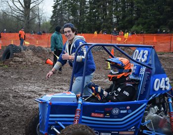 Max Johnson, left,&nbsp; captain of the Off-Road Illini team, runs alongside Matthew Lim, right, who is the co-machining lead and driver during the 2023 Baja SAE Oshkosh competition in Oshkosh, Wisc. from May 2-8. The team put their new steering wheel to work finishing in 13th place out of 82 competitors.