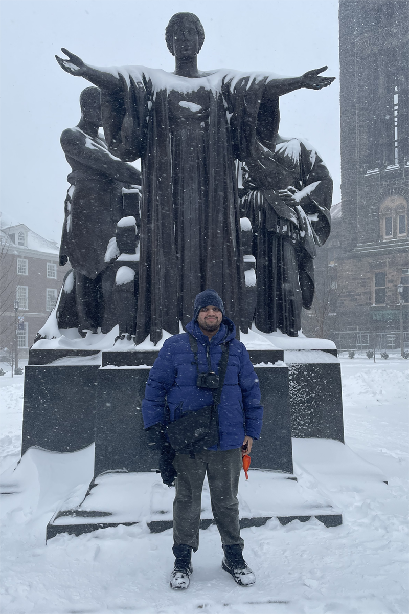MatSE alumnus Salil Paranjape ('23, M.S.) poses for a photo in front of a snow-covered Alma Mater on the University of Illinois Urbana-Champaign campus in Urbana, Ill.