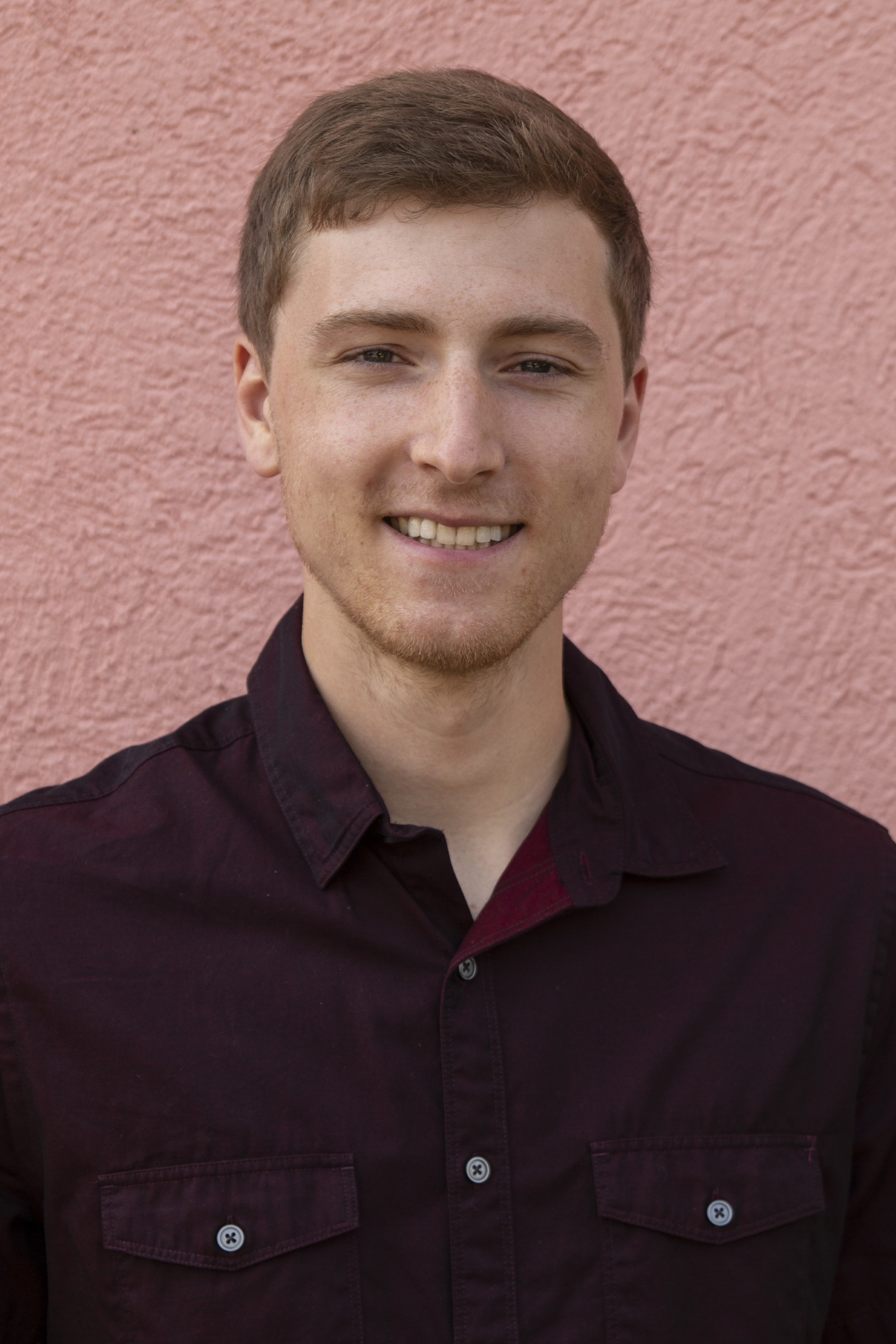 Man in button-up shirt smiles for camera