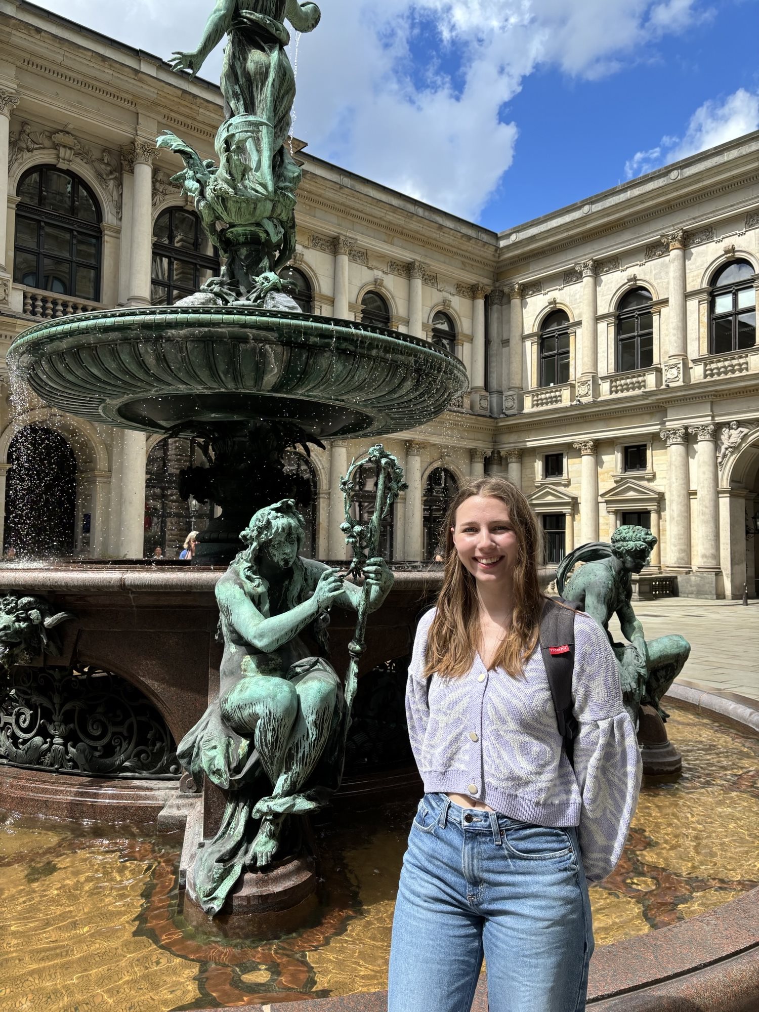 Laura Klusendorf posing in front of a statue for a picture during an overseas research trip.